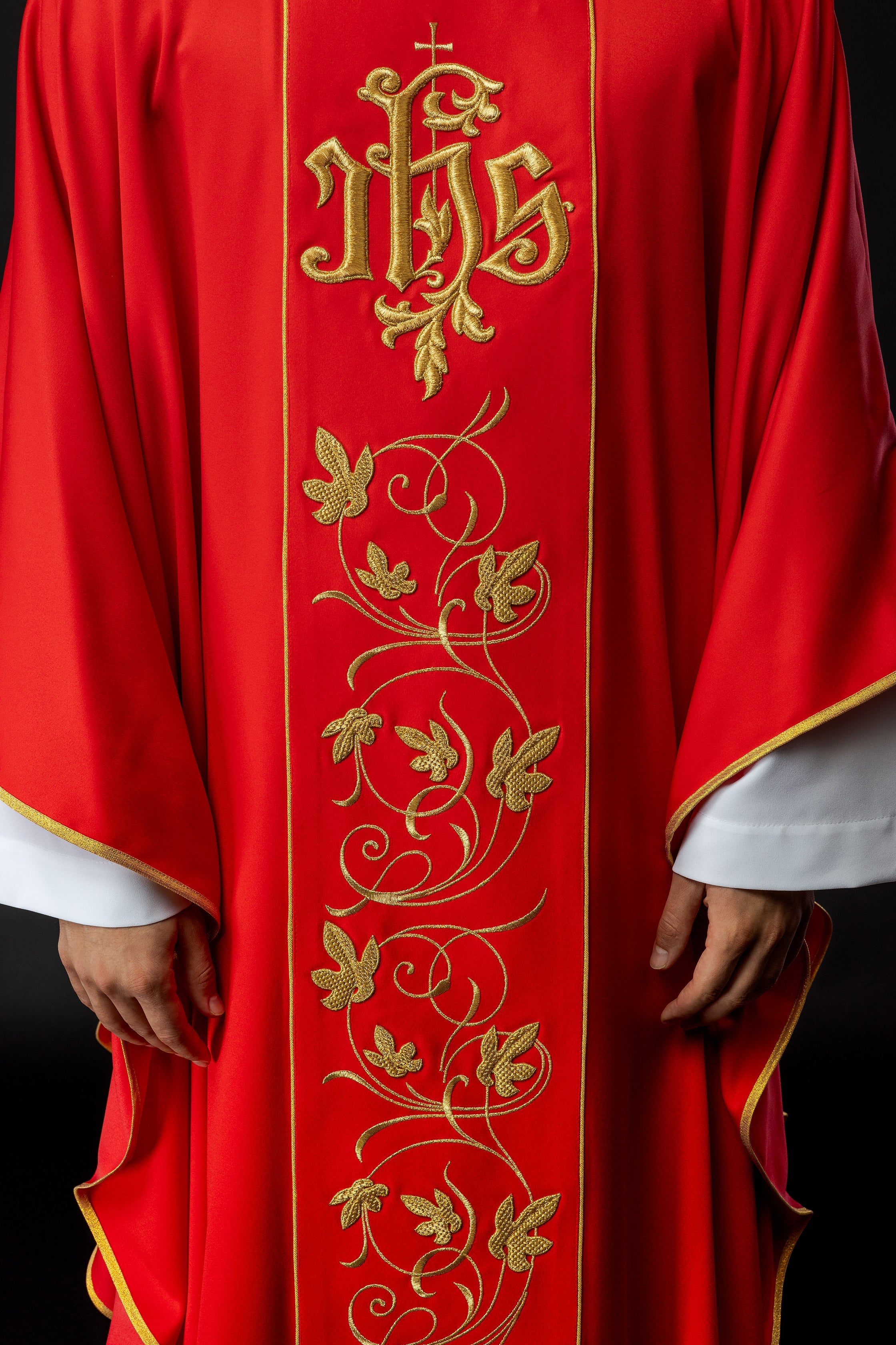 Casulla litúrgica roja con cinturón ricamente decorado con motivos florales e IHS